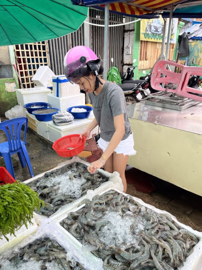 Cambodian woman spending Cambodian currency at a market in Siem Reap