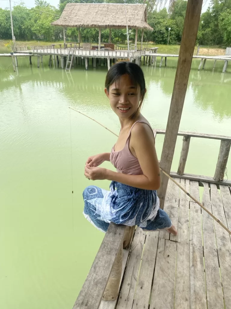 Girl fishing at Bamboo Bridge near Angkor Wat Siem Reap