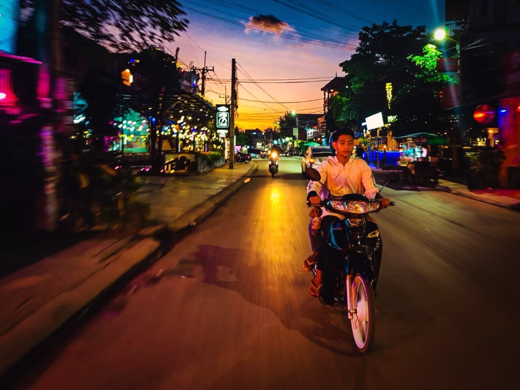 Riding a scooter at night on Sok San Road Siem Reap Cambodia
